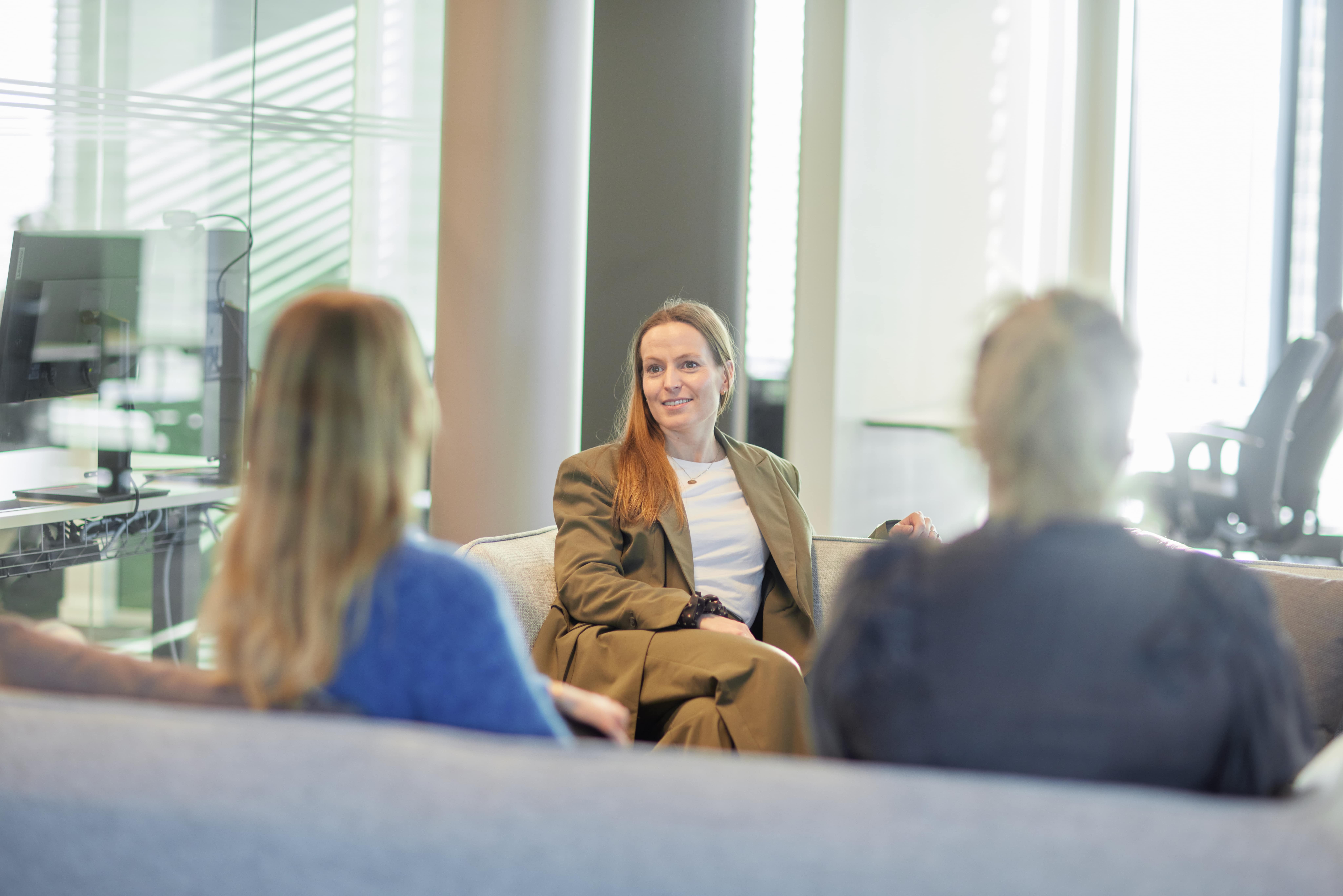 Three people discussing in lounge setting